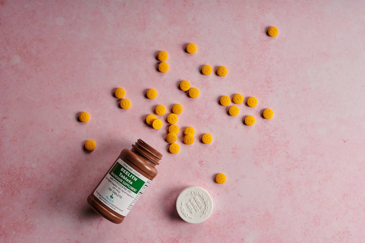 safe supplements for menopause displayed on a wooden table with water glass and journal